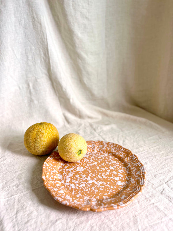 brown and white round spatterware platter 14" with grapefruit