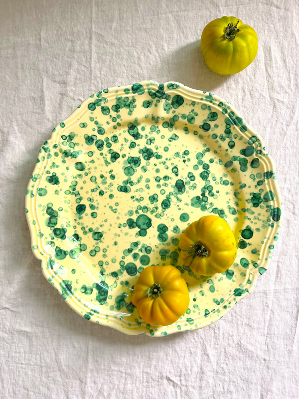 green and cream round spatterware platter with tomatoes