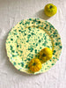 green and cream round spatterware platter with tomatoes