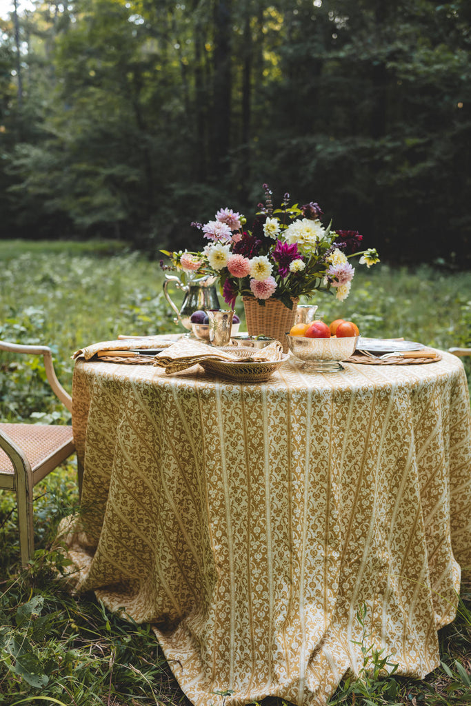 yellow and cream striped linen tablecloth with floral arrangement