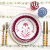 white tablecloth with blue and yellow floral stripe pattern with bloom plate