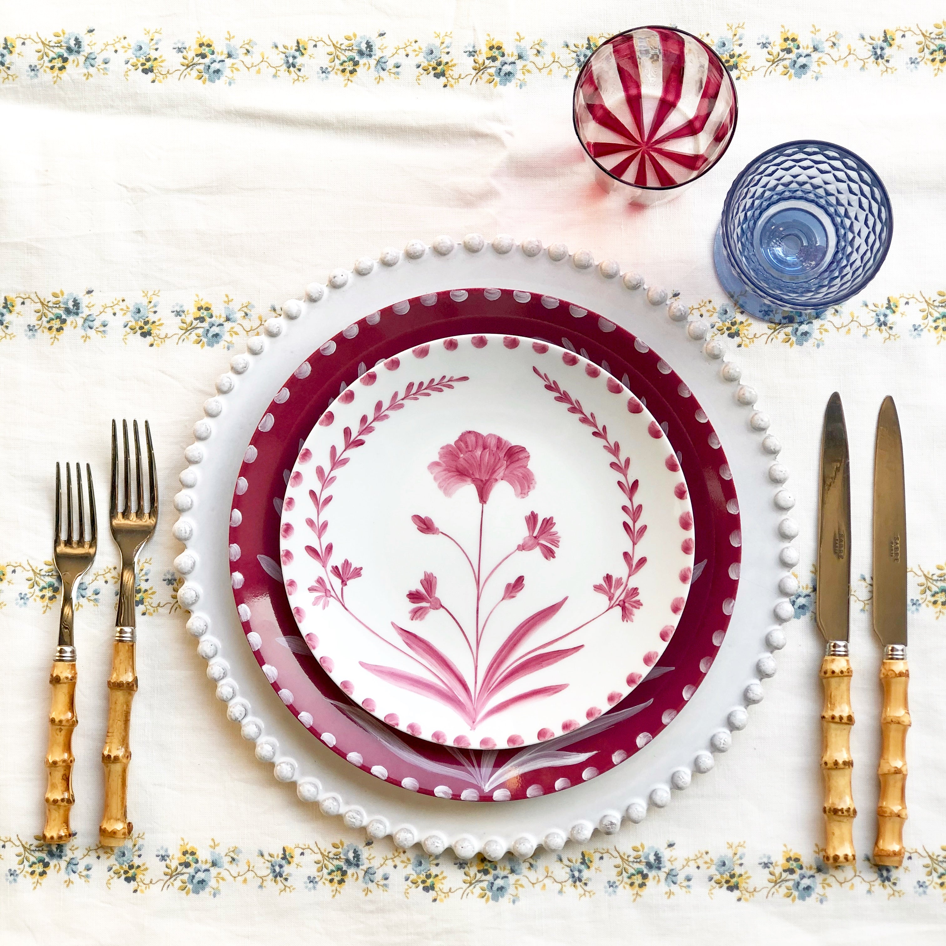 white limoges porecelain salad plate with hand painted red floral design in placesetting