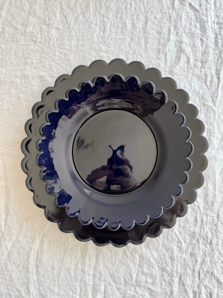 dark blue salad plate with scalloped edge with dinner plate