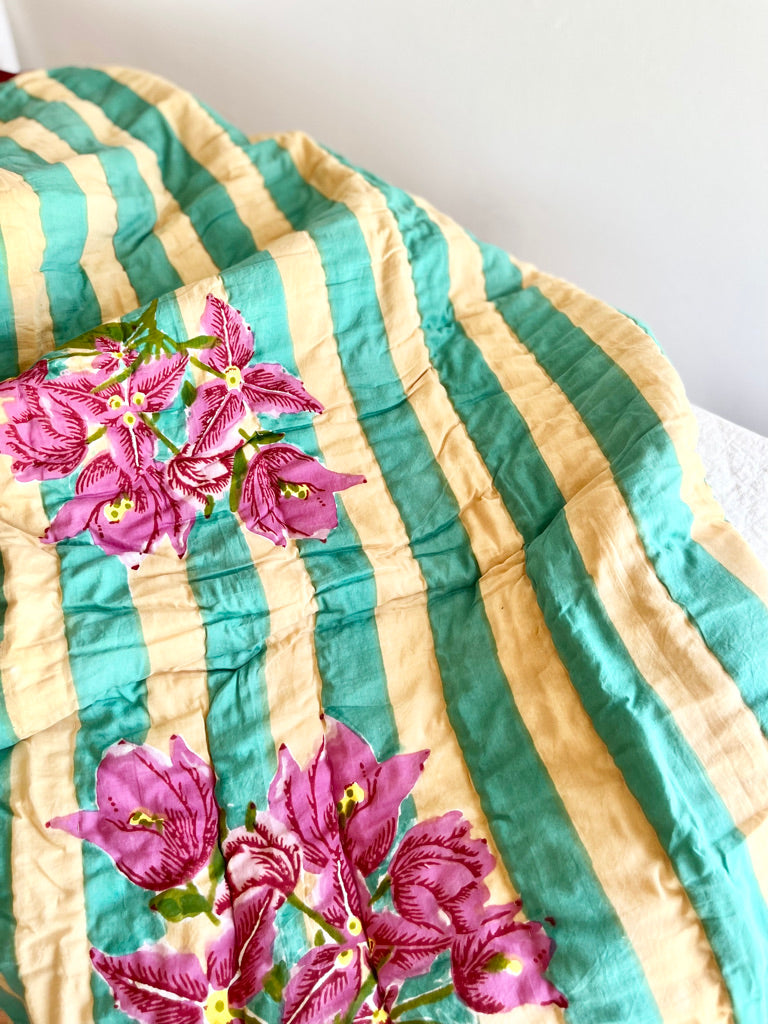 green striped cotton quilt with red border and bougainvillea in center 27 x 40 inches flower detail view