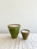 terra cotta candle with a mossy and aged green exterior close of small and medium together