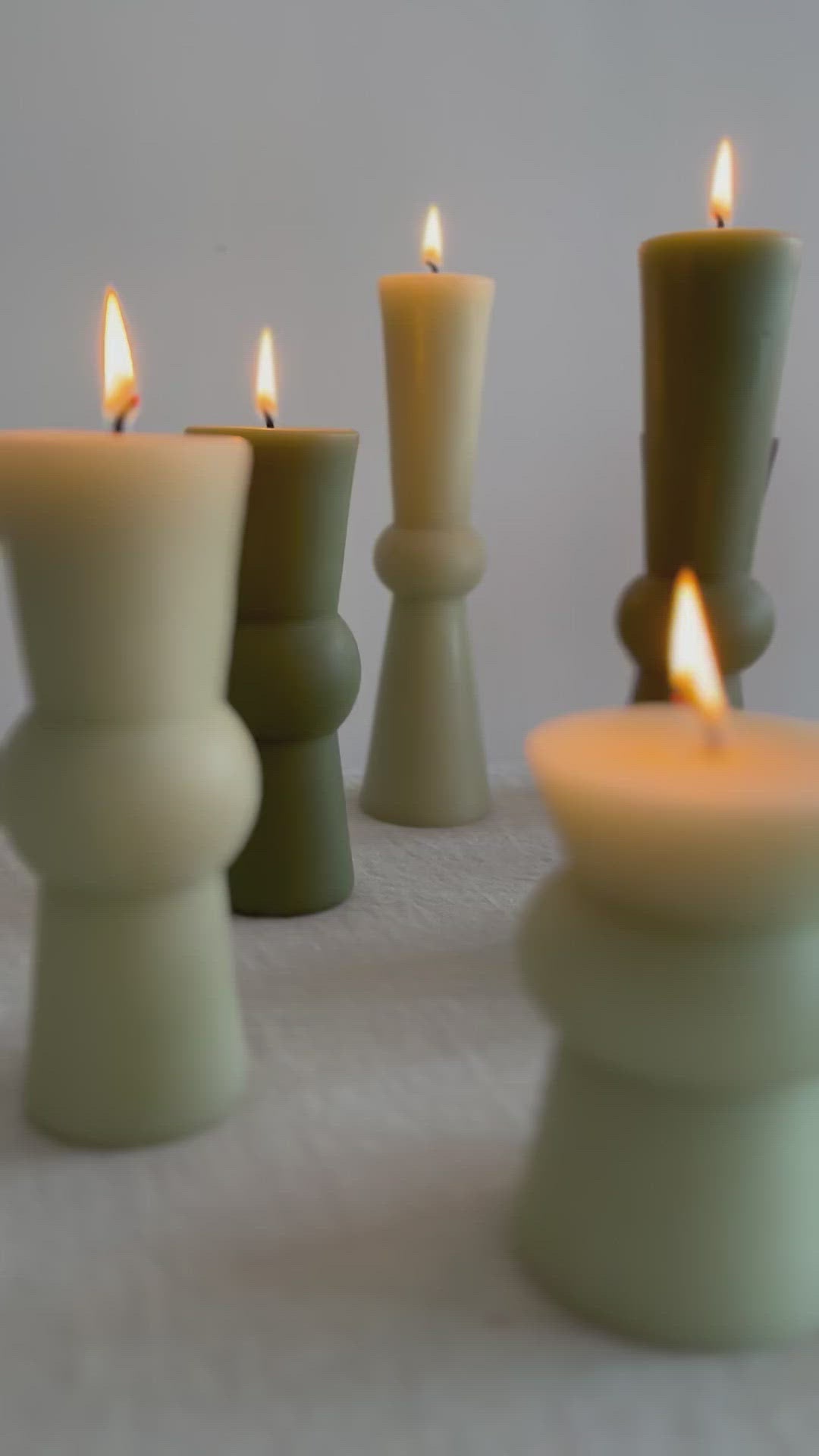 video of assorted totem colors in earth tones on table with flame lit.