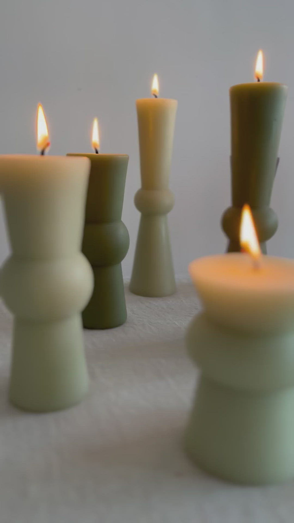 video of assorted totem colors in earth tones on table with flame lit.