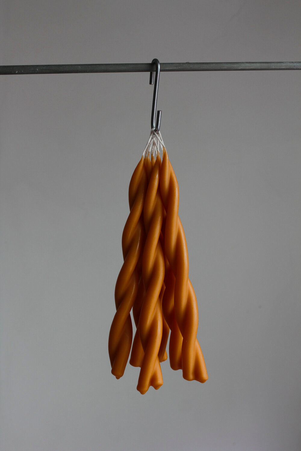 twisted candles by wax atelier clementine tapers hanging on hook