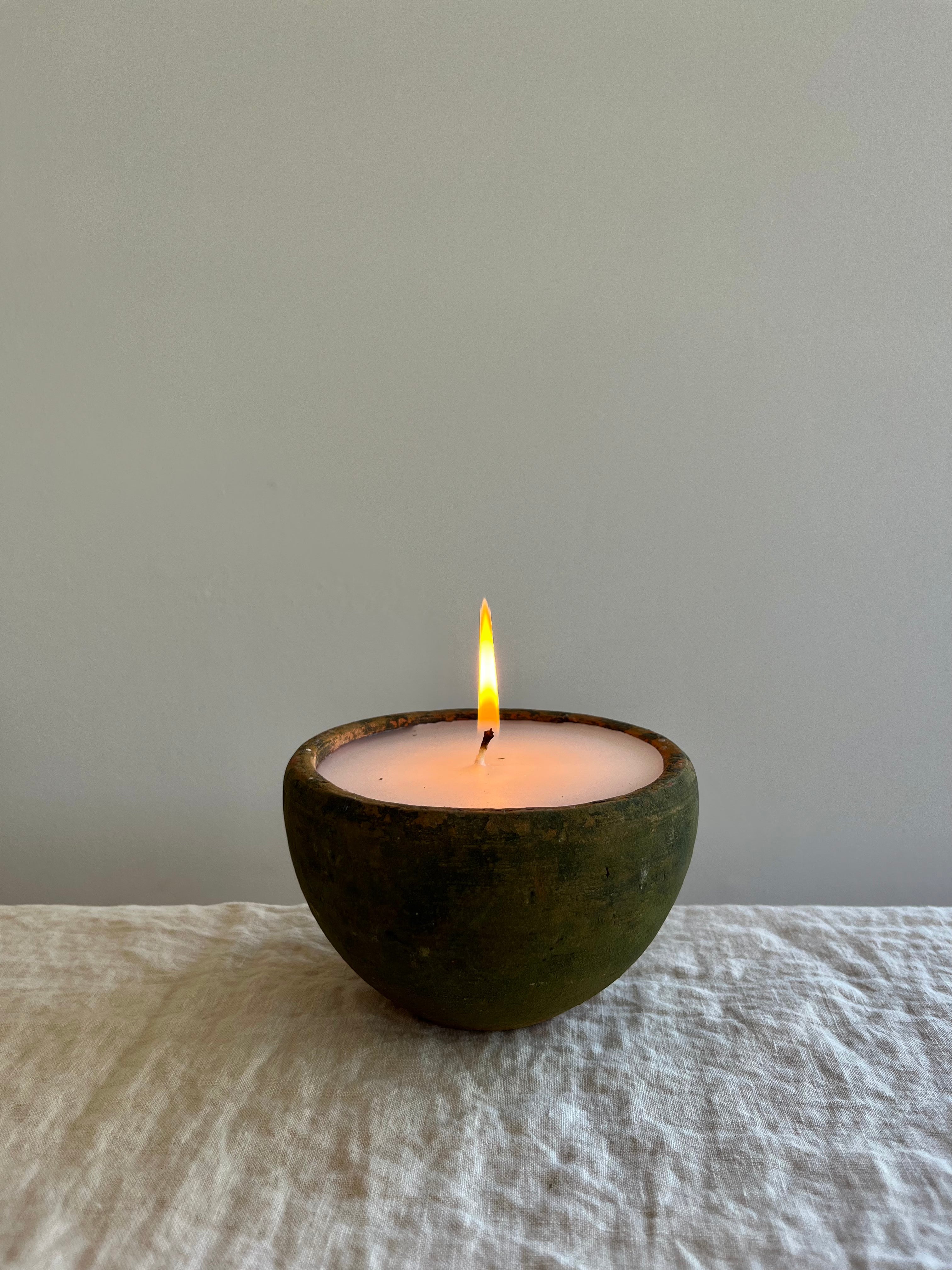 candle in moss covered terra cotta pot