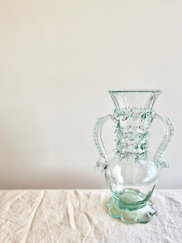 clear glass vase with two handles 14 inches tall on white table