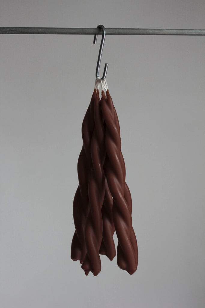 twisted candles by wax atelier choco tapers hanging on hook