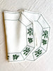 octagonal white linen placemat with olive green embroidery 19.5" by 16"