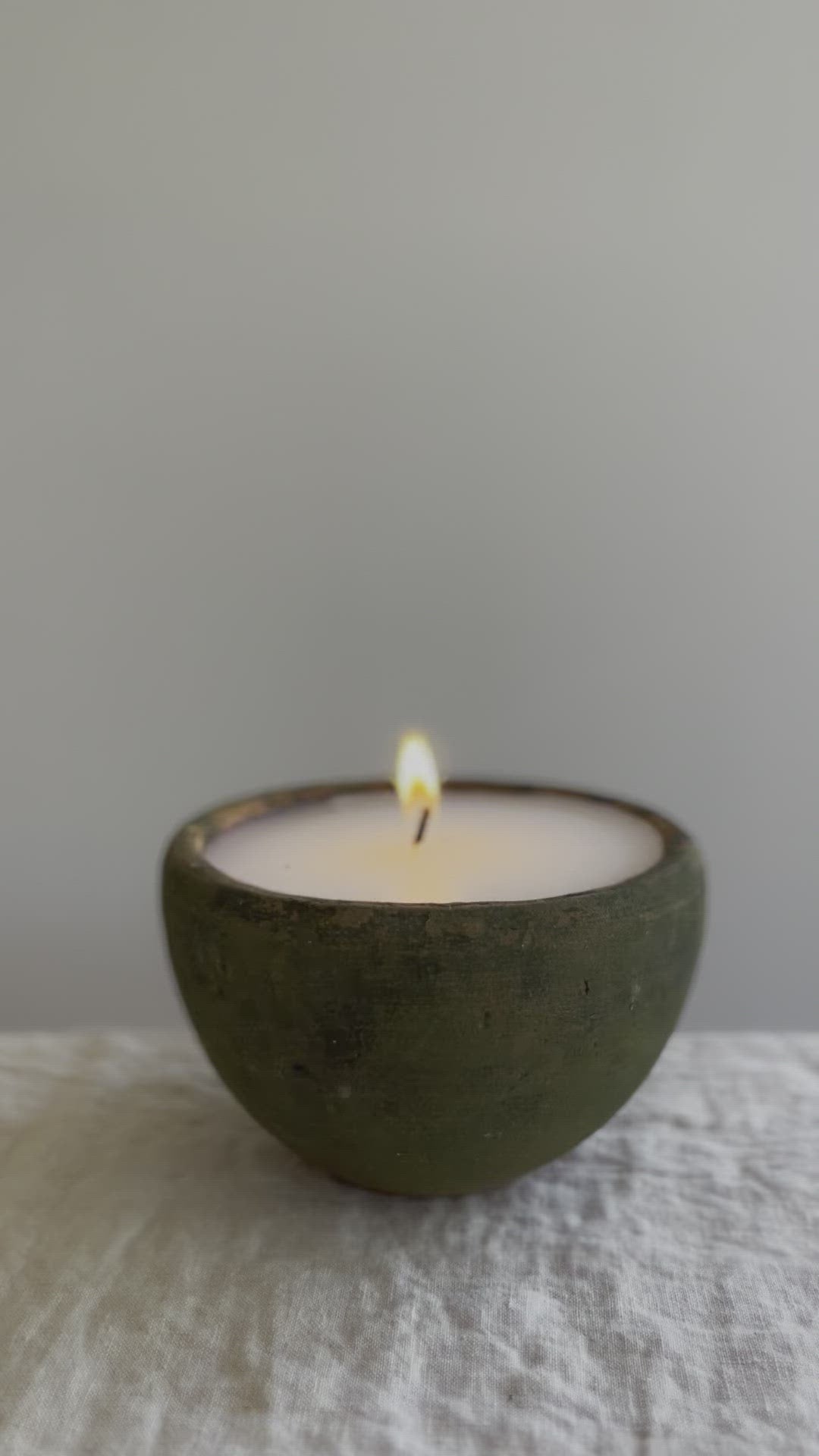 video of candle in moss covered terra cotta pot