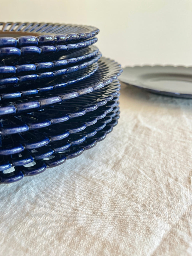dark blue salad plate with openwork rim and scalloped edge stacked