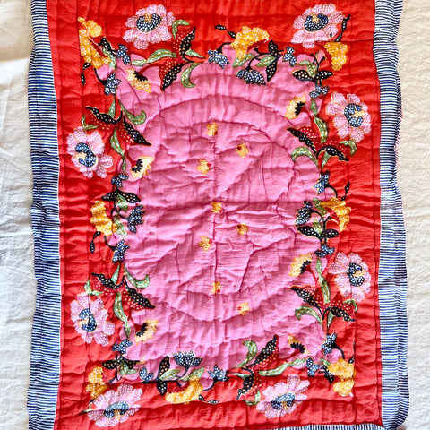 red and pink cotton quilt with pink and yellow flowers and a blue and white striped border 27 x 40 inches