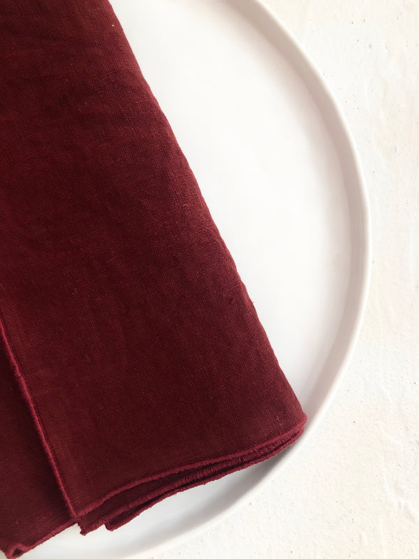 red linen rolled edge linen napkins with red edge folded on plate 18 inch square