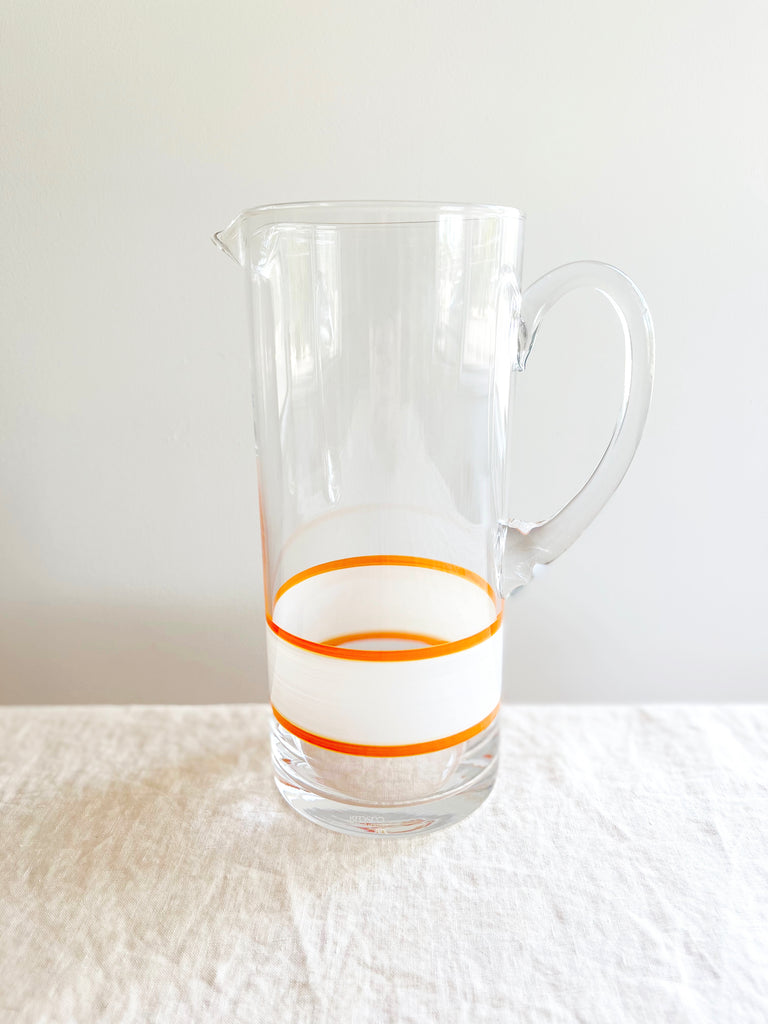 glass pitcher with hand painted white and orange stripes 10 inches tall
