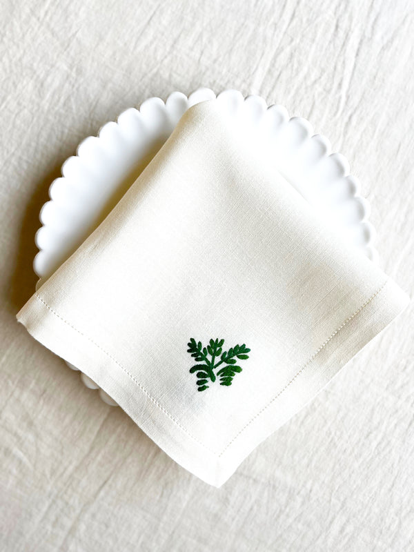 white hand embroidered linen napkins with dark green leaves in corner 16 inches square