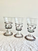 clear hand blown glass goblet with lavender glass accents on linen tablecloth