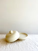 round cream covered dish 6 inches in diameter with lid off