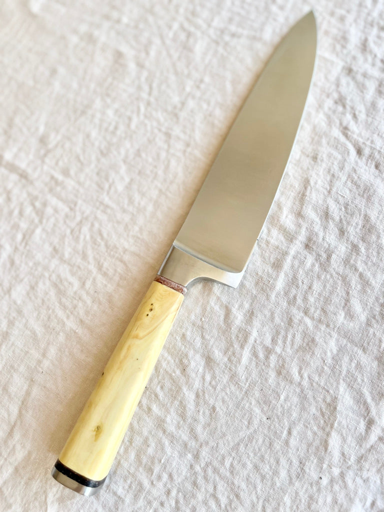 chef knife with boxwood handle diagonal on white table by palleras solsona 