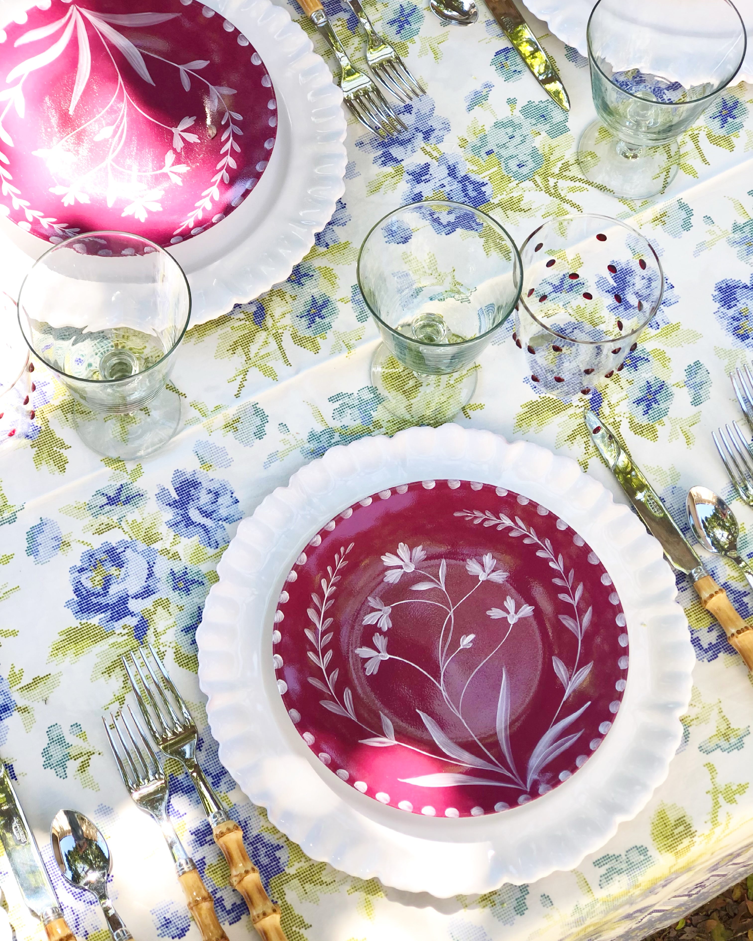 red limoges porecelain salad plate with hand painted white floral design with white charger