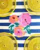 yellow round woven placemat on blue and white striped cloth