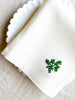 white hand embroidered linen napkins with dark green leaves in corner 16 inches square detail view
