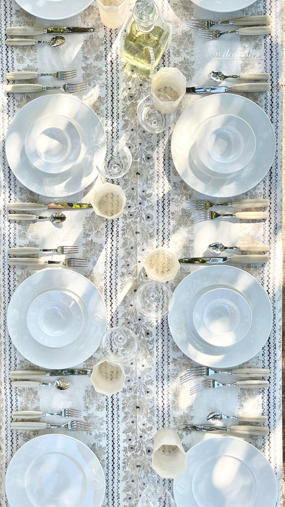 white charger with greek medallion design in tablescape top view