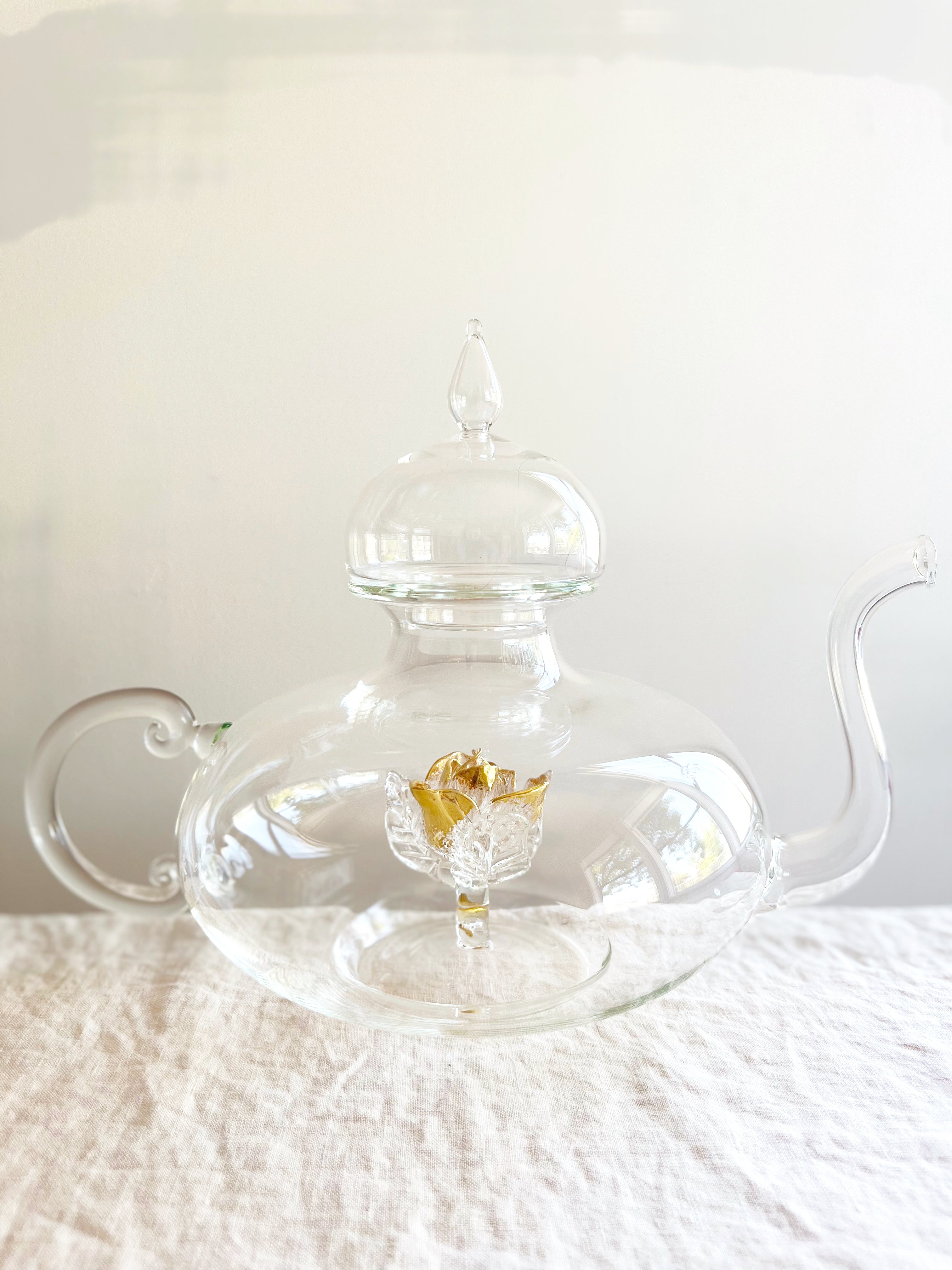 clear hand blown glass teapot with gold glass rose in bottom