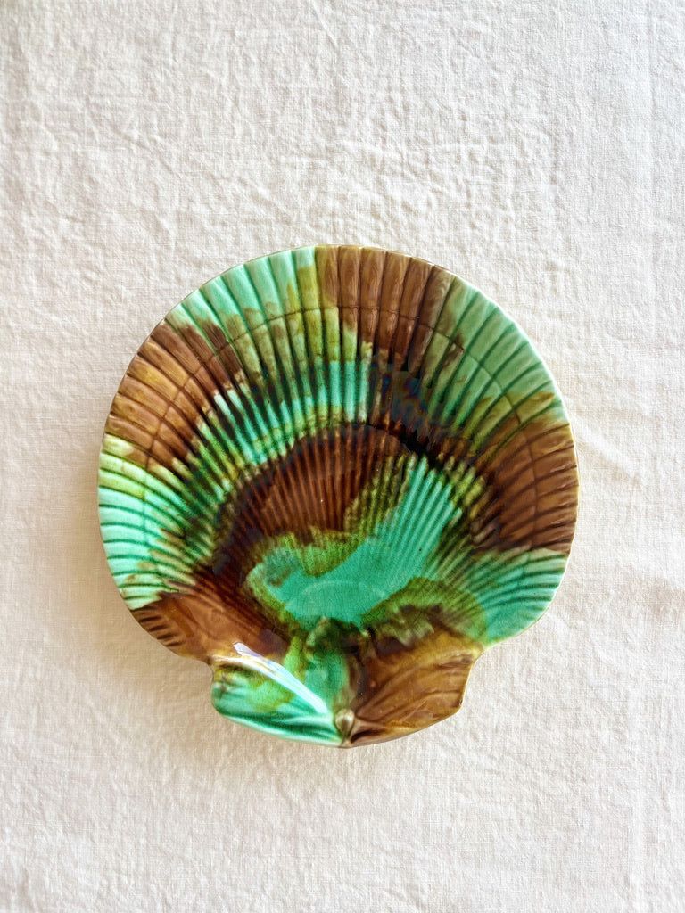 green and brown shell shaped majolica plate on linen
