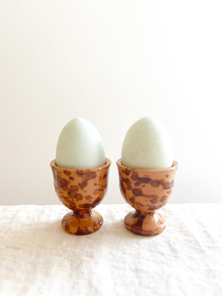 fasano egg cups with brown splatter pattern holding eggs