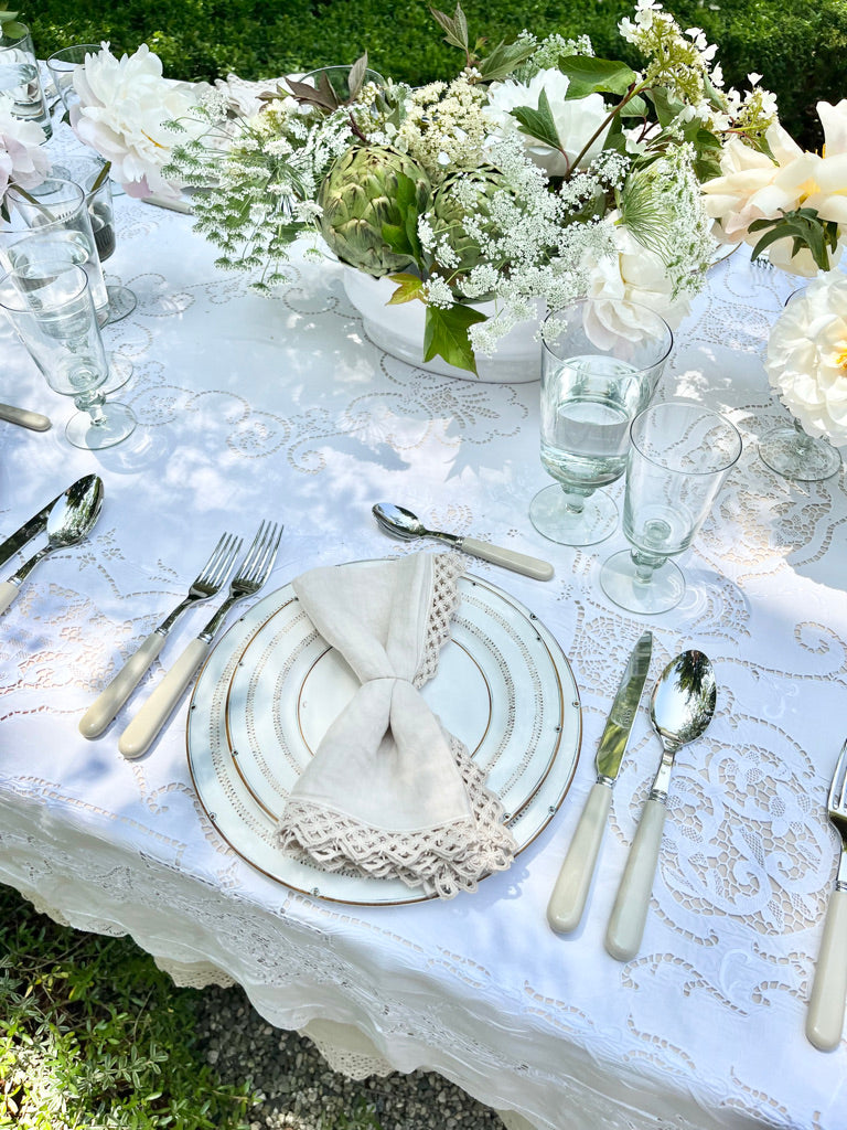 sabre stainless steel flatware set with white resin handle with lace tablecloth