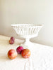 white openwork footed bowl on white linen tablecloth