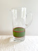 glass pitcher with hand painted green and red stripe on white table