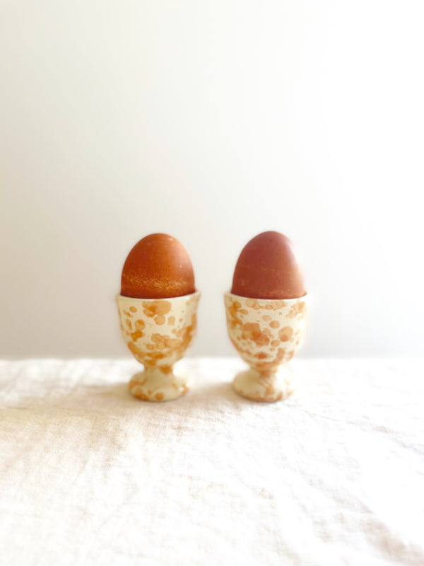 fasano egg cups with splatter pattern in natural holding eggs