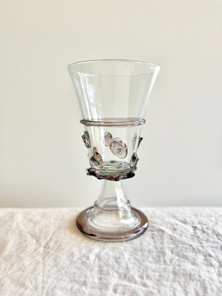 clear hand blown glass goblet with lavender glass accents on white table