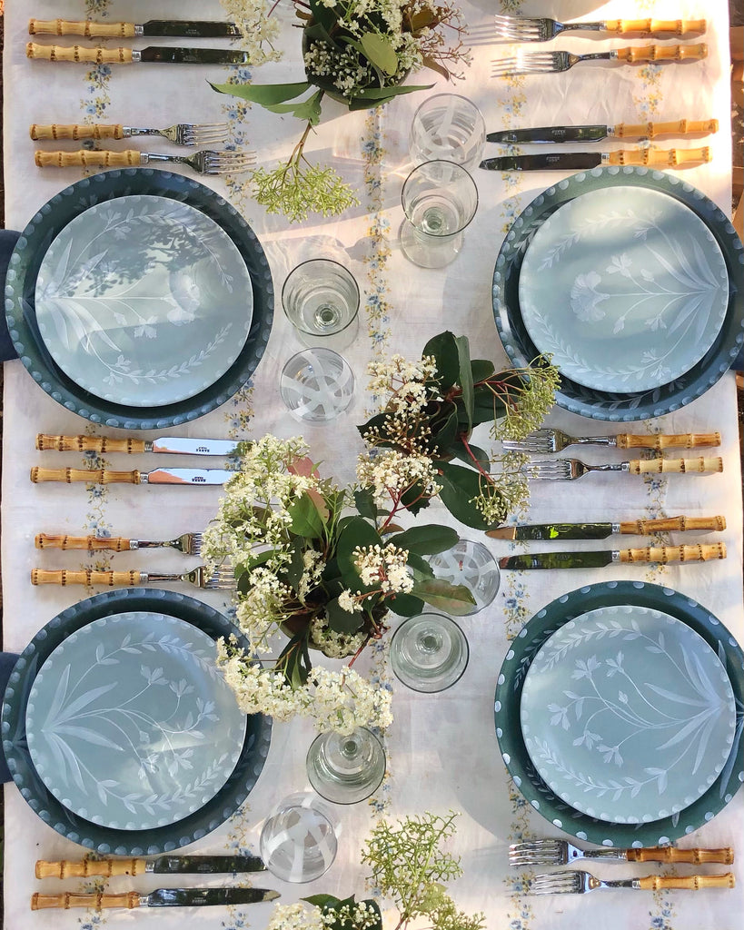 white tablecloth with blue and yellow floral stripe pattern with essex bamboo flatware