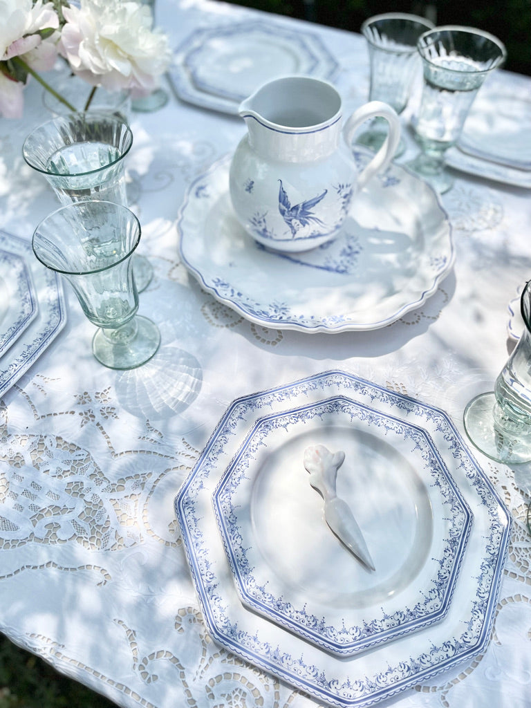 blue and white pitcher with blue phoenix design on lace tablecloth