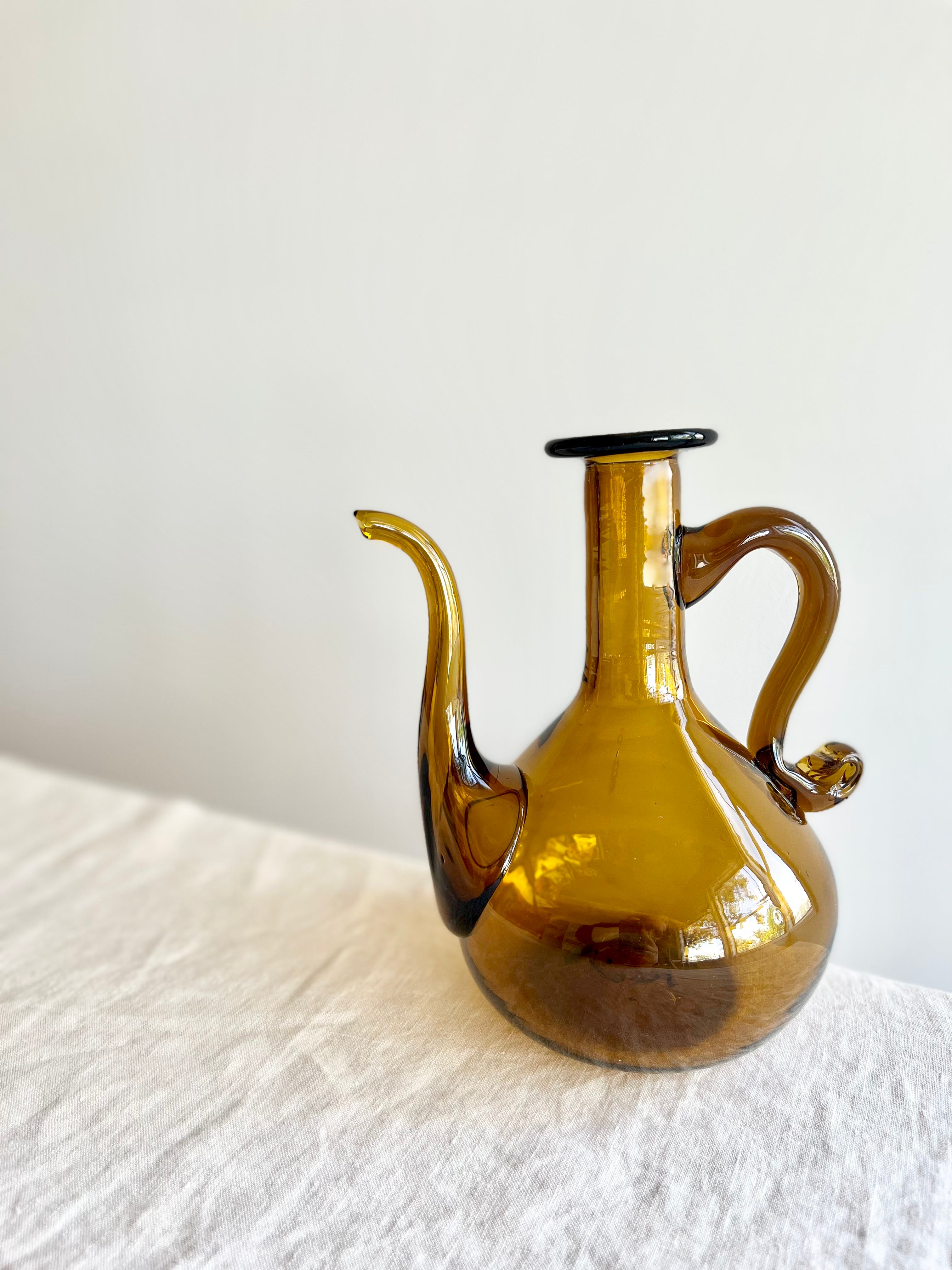 blown glass cruet by gordiola on white table tobacco color 