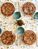 white tablecloth with blue and brown floral pattern with placesetting