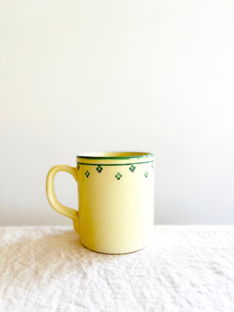 cream mug with green rim and dots around edge