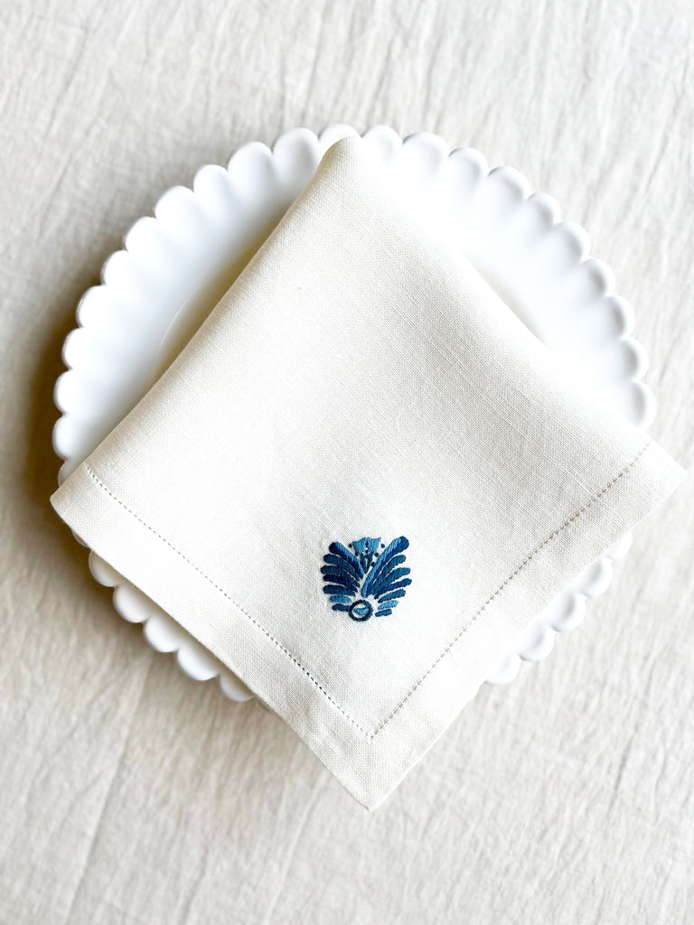 white hand embroidered linen napkins with blue palm frond in corner 16 inches square