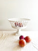 white openwork footed bowl with peaches