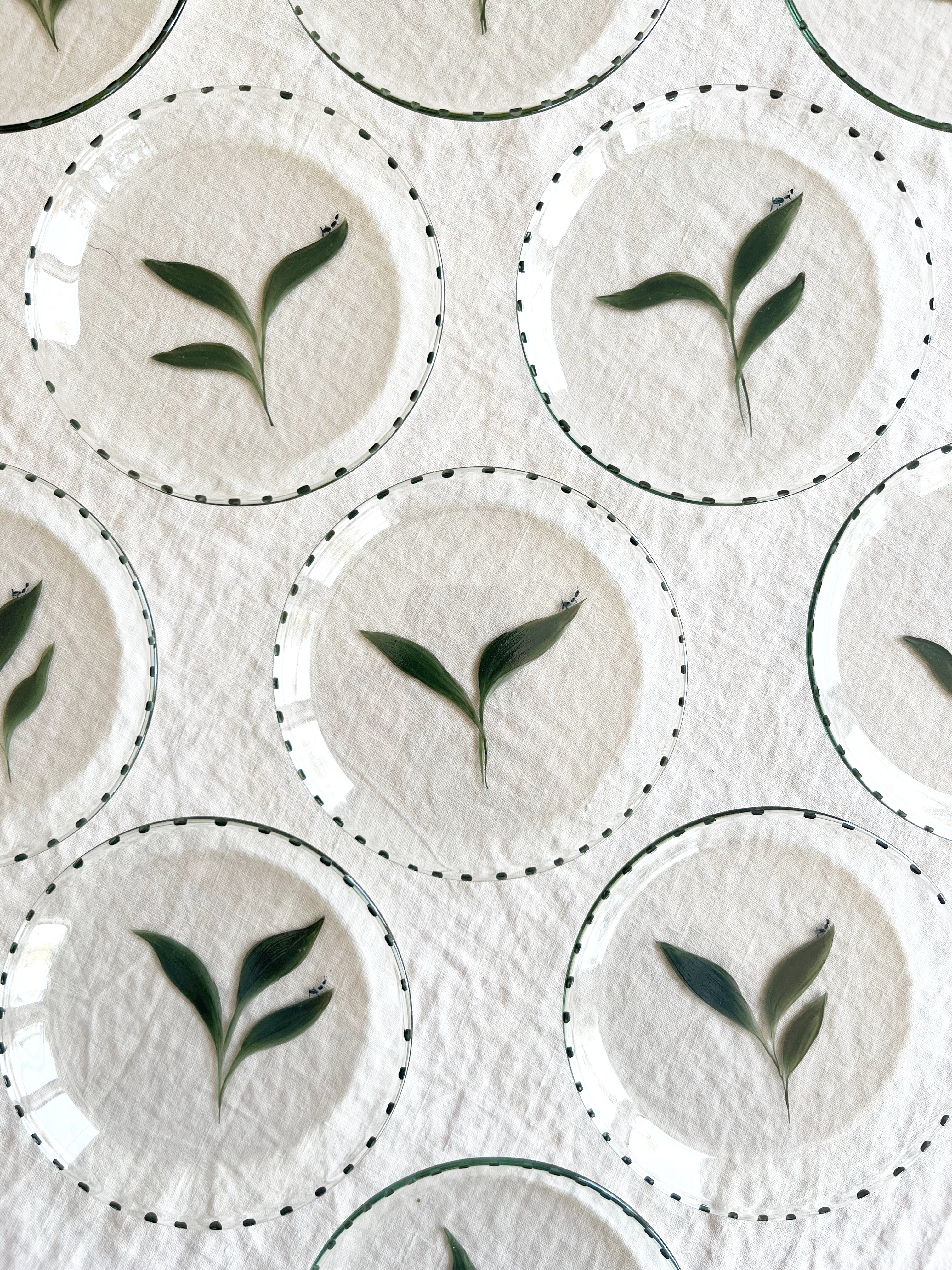 clear glass bread plate with hand painted green leaf with small ant top view