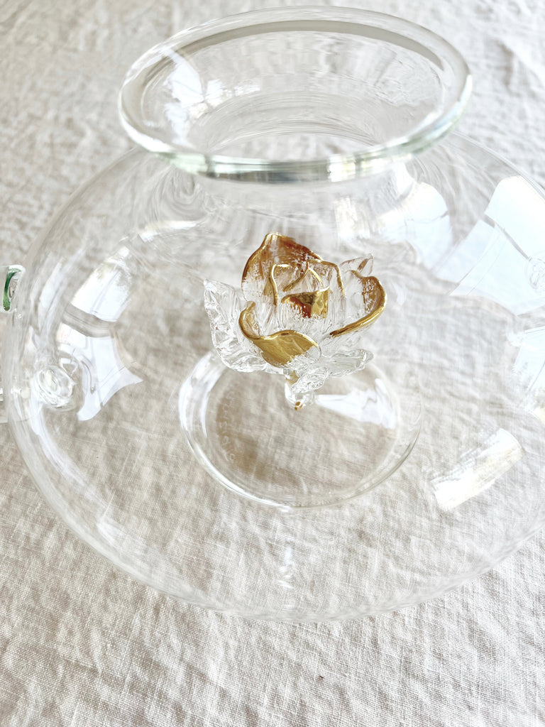 clear hand blown glass teapot with gold glass rose in bottom flower detail view