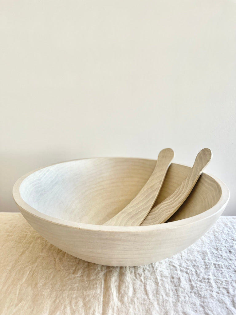 salad servers made of maplewood in bowl side view