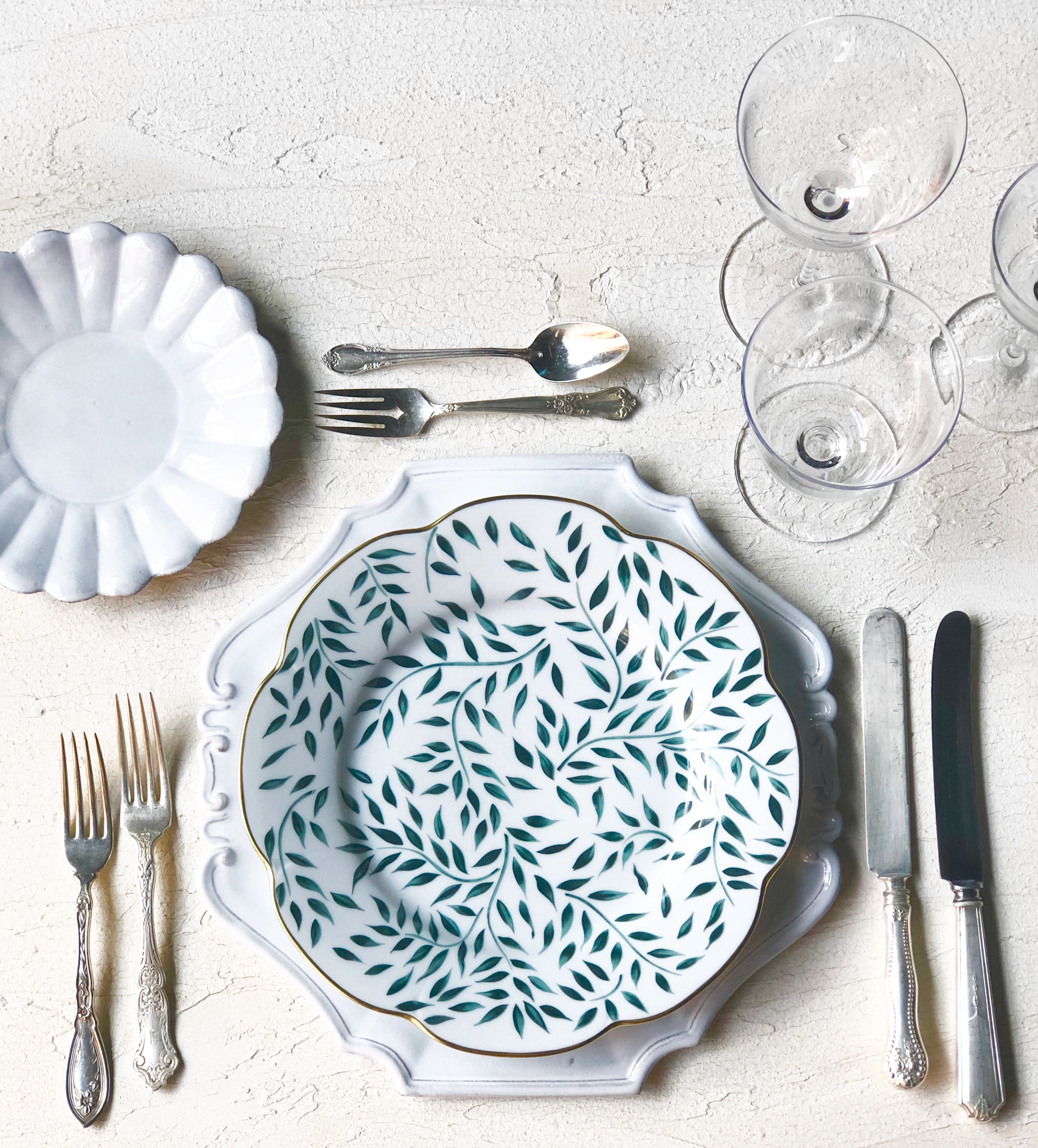 hand painted limoges porcelain dinner plate with green vine pattern and gold rim on white table