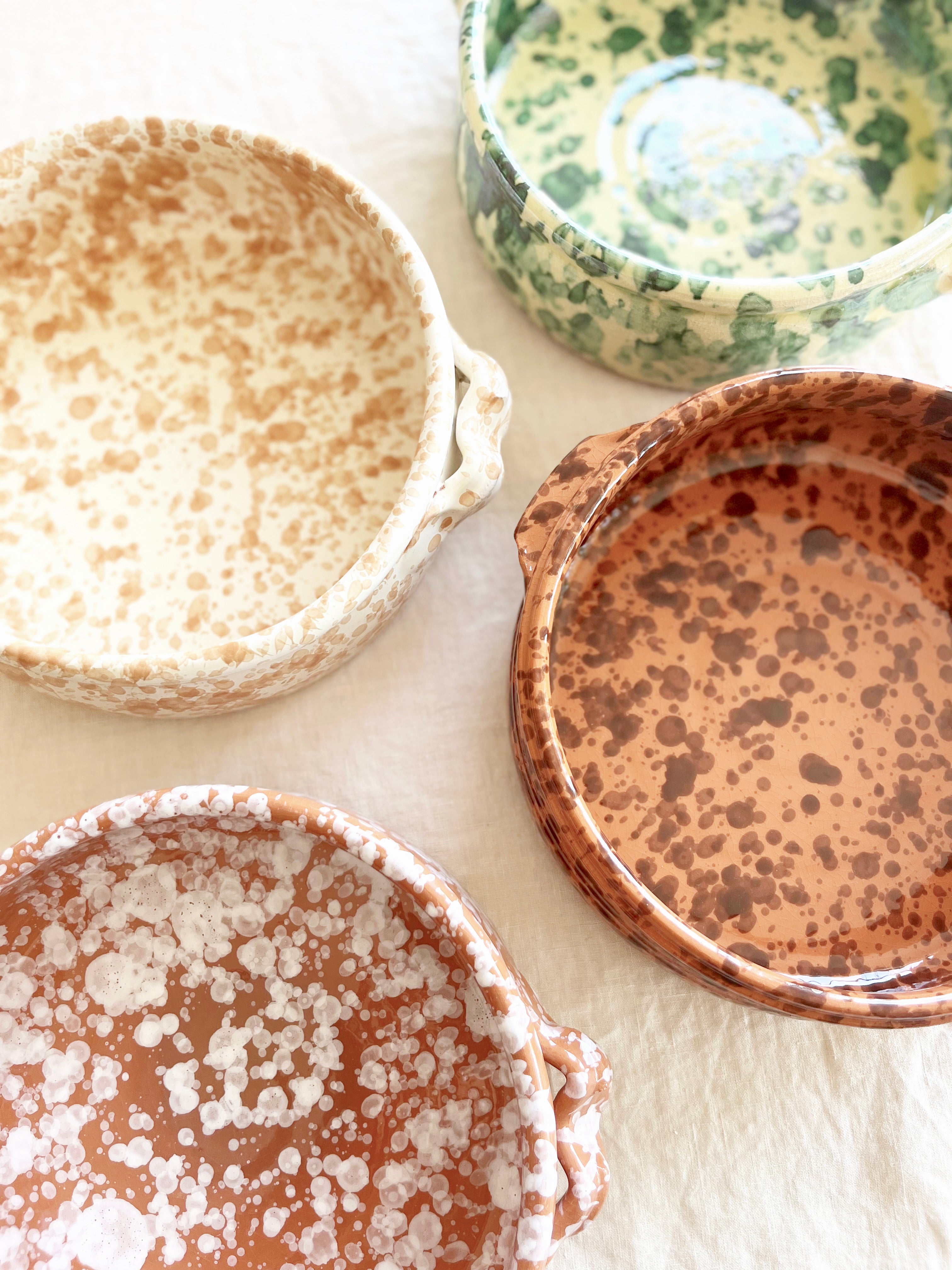 brown oven safe dish with cream speckle pattern 9" diameter on linen tablecloth