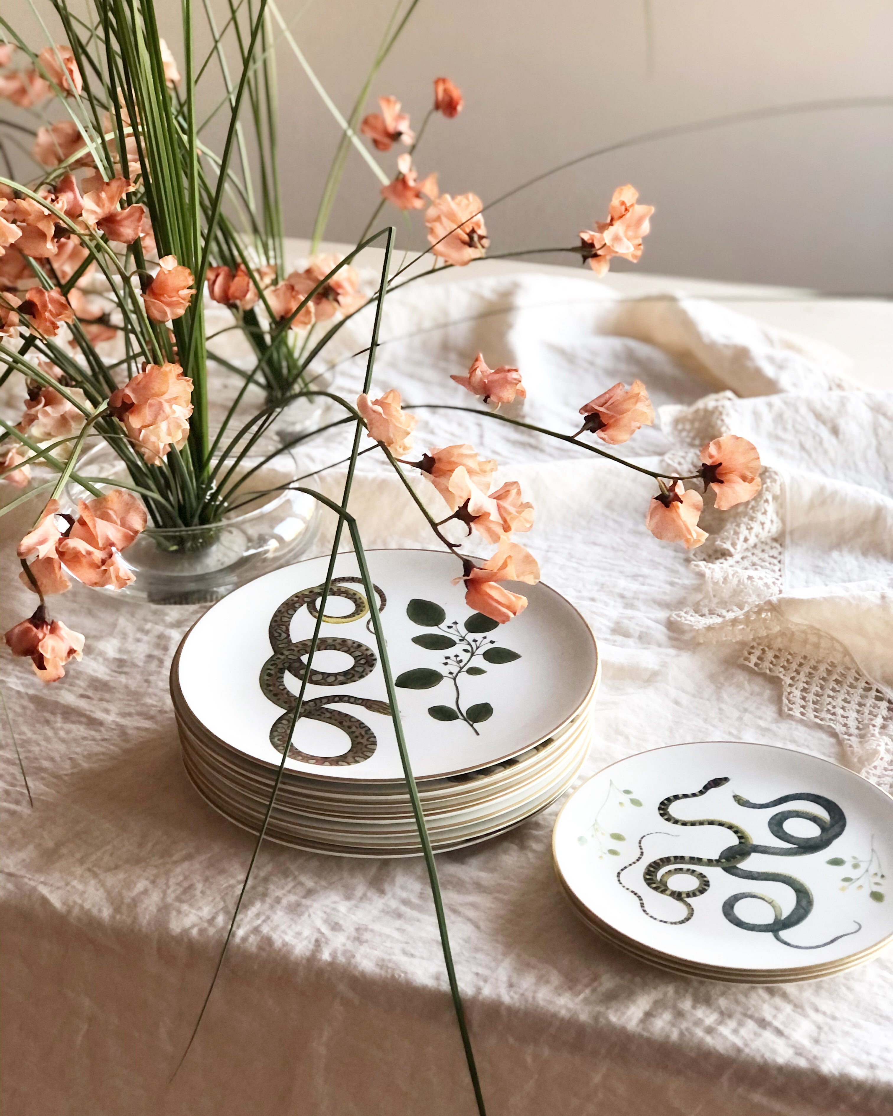 gold rimmed white dinner plate with serpent and leaf 9.5" diameter on table